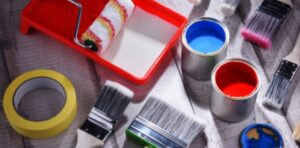 A view of all tools important of painting a wall paint color brushes and other