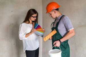 a woman and a painter selecting the color from the color palette to paint