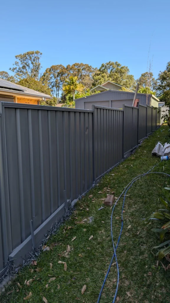 Metal boundary fence repainted in dark Monument at a Rothbury property.